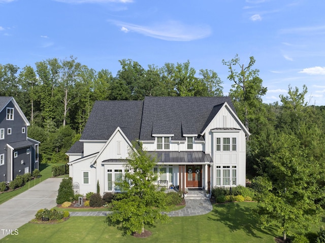 2153 Princeville Dr, Apex, NC 27523 - modern farmhouse style home featuring board and batten siding, a standing seam roof, a front yard, and driveway