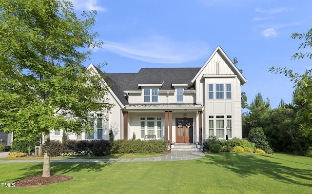 2153 Princeville Dr, Apex, NC 27523 - modern inspired farmhouse featuring a standing seam roof, board and batten siding, a front yard, roof with shingles, and a metal roof