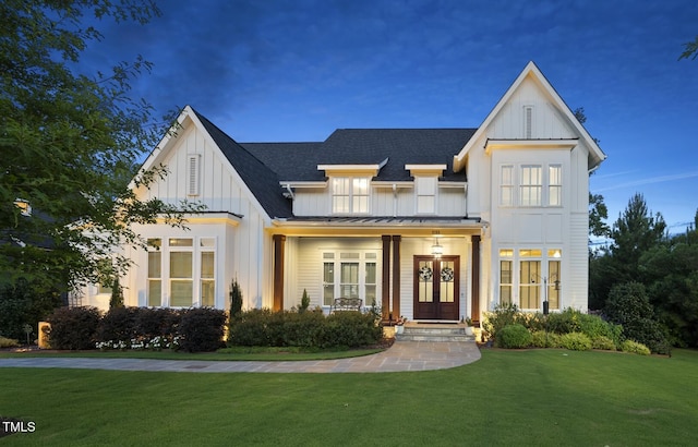 2153 Princeville Dr, Apex, NC 27523 - modern farmhouse featuring board and batten siding, a standing seam roof, a front yard, a metal roof, and a shingled roof