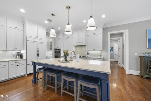 2153 Princeville Dr, Apex, NC 27523 - kitchen featuring paneled fridge, backsplash, white cabinets, a breakfast bar area, and ornamental molding