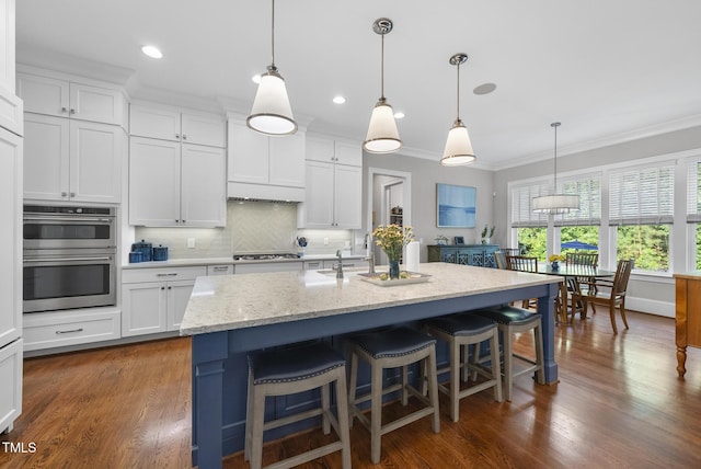 2153 Princeville Dr, Apex, NC 27523 - kitchen with gas stovetop, crown molding, double oven, white cabinets, and backsplash