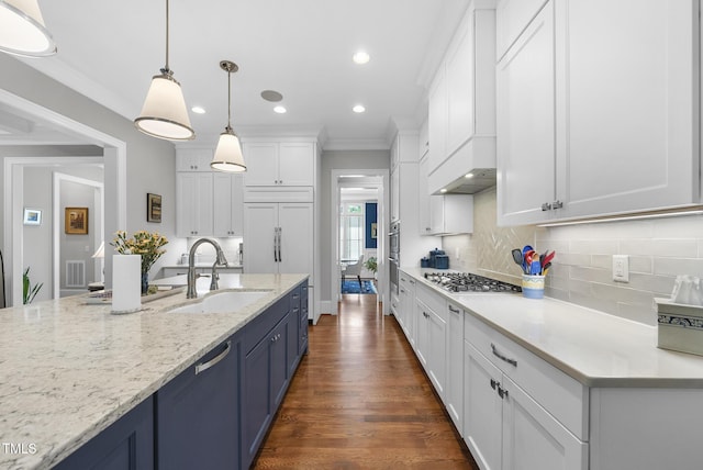 2153 Princeville Dr, Apex, NC 27523 - kitchen featuring stainless steel appliances, white cabinetry, blue cabinets, tasteful backsplash, and ornamental molding
