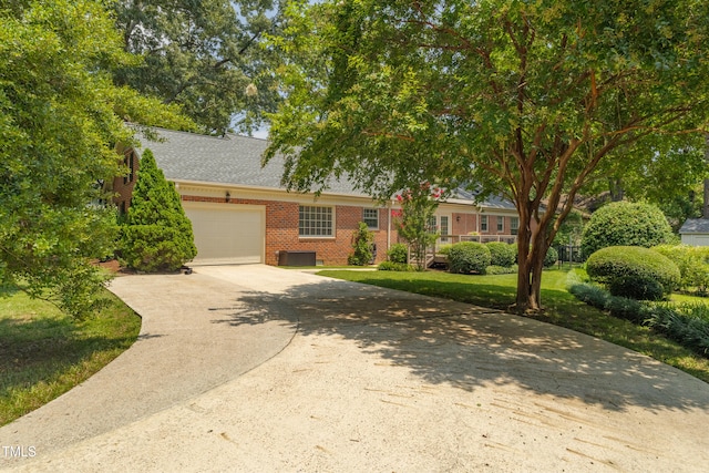 4009 Pepperton Dr, Raleigh, NC 27606 - view of front of property with brick siding, a garage, driveway, a front yard, and roof with shingles