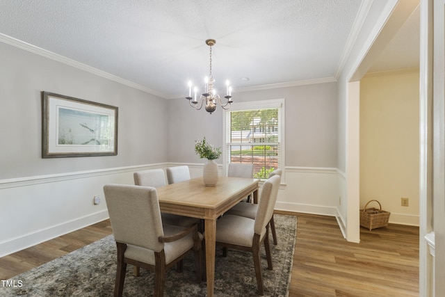 4009 Pepperton Dr, Raleigh, NC 27606 - dining room featuring wood finished floors, crown molding, a chandelier, and a textured ceiling