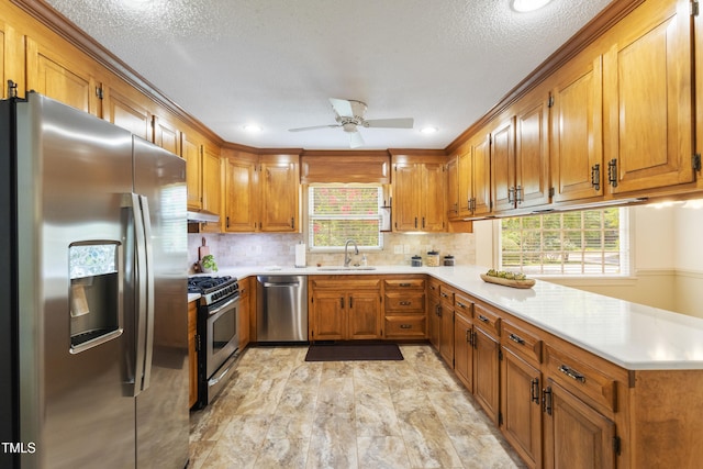 4009 Pepperton Dr, Raleigh, NC 27606 - kitchen featuring stainless steel appliances, a peninsula, brown cabinets, light countertops, and recessed lighting