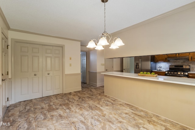4009 Pepperton Dr, Raleigh, NC 27606 - kitchen featuring stainless steel appliances, a chandelier, light countertops, under cabinet range hood, and ornamental molding