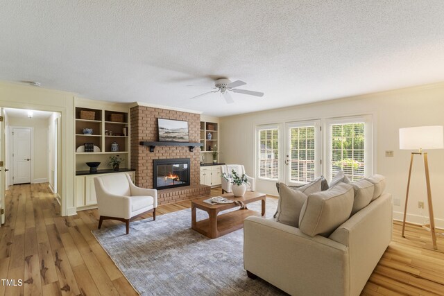 4009 Pepperton Dr, Raleigh, NC 27606 - living area featuring a textured ceiling, a ceiling fan, hardwood / wood-style floors, a fireplace, and built in features