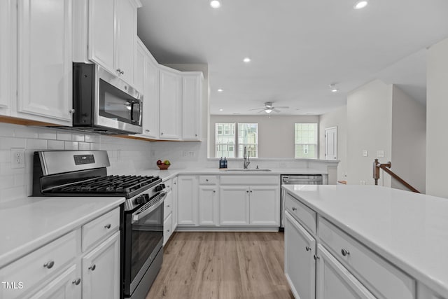 1119 Platform Dr, Apex, NC 27502 - kitchen featuring stainless steel appliances, recessed lighting, light wood-style floors, white cabinetry, and decorative backsplash