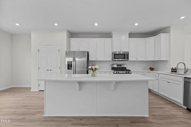 1119 Platform Dr, Apex, NC 27502 - kitchen featuring stainless steel appliances, a kitchen island, light countertops, white cabinetry, and tasteful backsplash