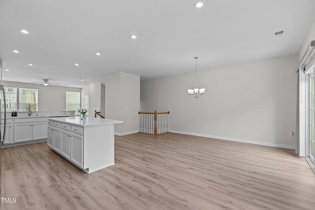 1119 Platform Dr, Apex, NC 27502 - kitchen featuring light wood finished floors, light countertops, recessed lighting, a chandelier, and a kitchen island