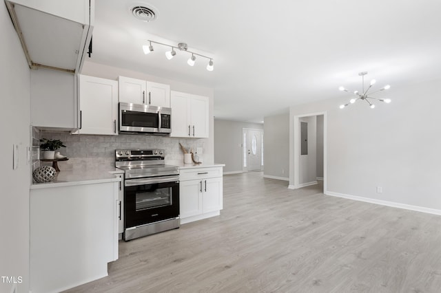 946 Jacksontown Rd, Henderson, NC 27537 - kitchen with appliances with stainless steel finishes, tasteful backsplash, light countertops, light wood-type flooring, and white cabinets