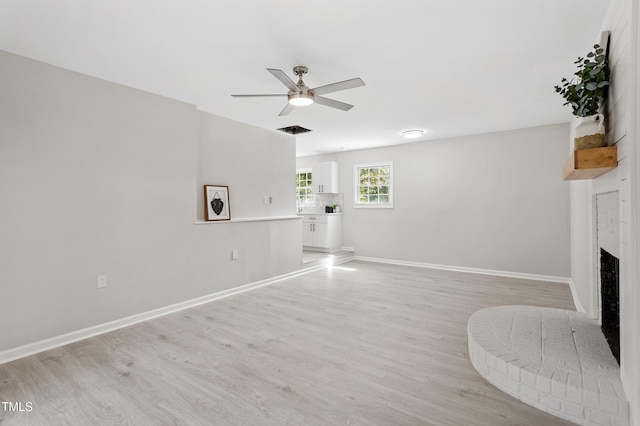 946 Jacksontown Rd, Henderson, NC 27537 - unfurnished living room with a ceiling fan, light wood finished floors, and a brick fireplace
