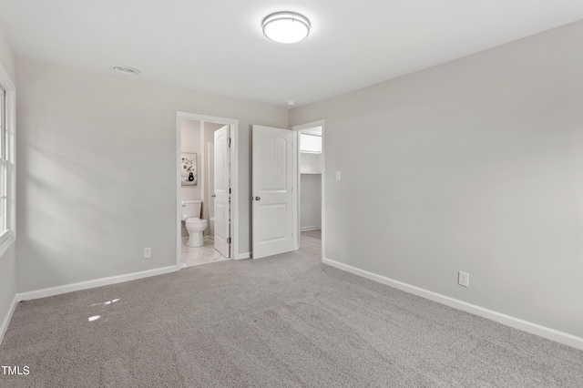 946 Jacksontown Rd, Henderson, NC 27537 - unfurnished bedroom featuring carpet, ensuite bathroom, and a spacious closet