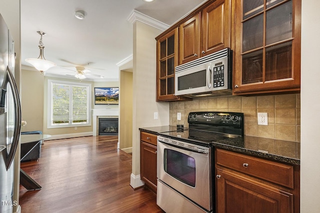 400 W Rosemary St Unit 102, Chapel Hill, NC 27516 - kitchen featuring appliances with stainless steel finishes, crown molding, tasteful backsplash, a fireplace, and a ceiling fan