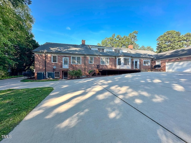141 Country Club Dr, Henderson, NC 27536 - view of front of home with a chimney, driveway, a deck, and brick siding