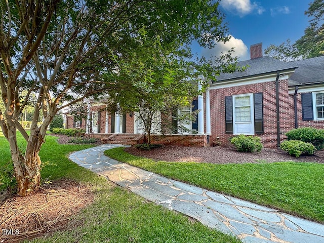 141 Country Club Dr, Henderson, NC 27536 - view of front facade with brick siding, a chimney, and a front lawn