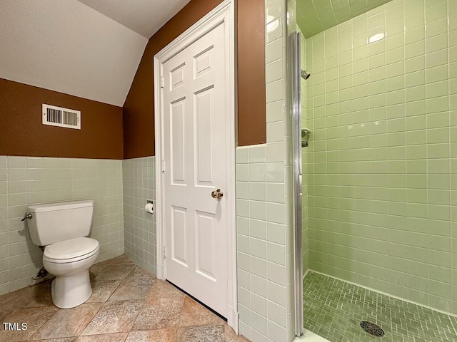 141 Country Club Dr, Henderson, NC 27536 - bathroom featuring a shower stall, tile walls, lofted ceiling, and wainscoting