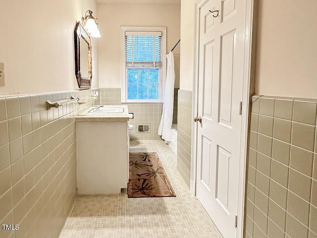 141 Country Club Dr, Henderson, NC 27536 - bathroom featuring tile walls, a wainscoted wall, tile patterned floors, and vanity
