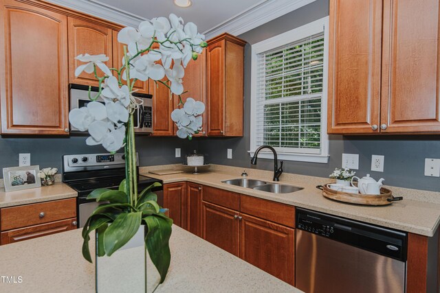 301 Grove Hall Ln, Mebane, NC 27302 - kitchen with stainless steel appliances, light countertops, crown molding, and brown cabinetry