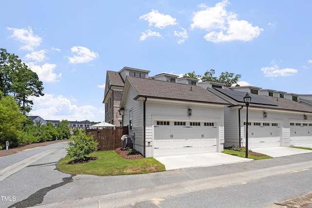930 Watercolor Way, Durham, NC 27713 - view of front of house with roof mounted solar panels, a shingled roof, and driveway