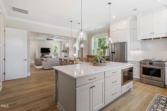 930 Watercolor Way, Durham, NC 27713 - kitchen featuring stainless steel appliances, a kitchen island, light countertops, healthy amount of natural light, and ornamental molding