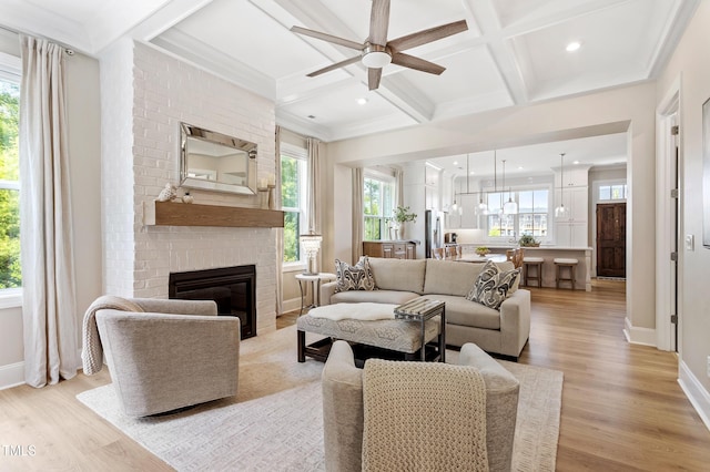 930 Watercolor Way, Durham, NC 27713 - living room featuring coffered ceiling, ceiling fan, light wood-style flooring, a brick fireplace, and beam ceiling