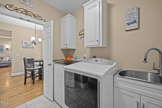 2424 Village Of Wakefield Dr, Zebulon, NC 27597 - laundry room featuring cabinet space, washer and dryer, a chandelier, and light tile patterned floors