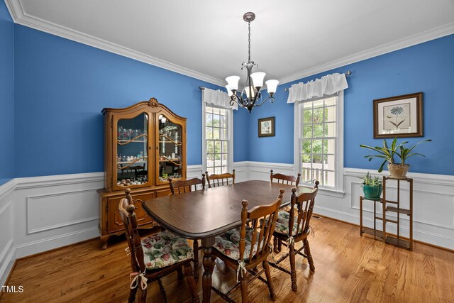 2424 Village Of Wakefield Dr, Zebulon, NC 27597 - dining space featuring a chandelier, a wainscoted wall, wood finished floors, and crown molding