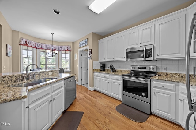 2424 Village Of Wakefield Dr, Zebulon, NC 27597 - kitchen with stainless steel appliances, white cabinetry, a chandelier, and backsplash