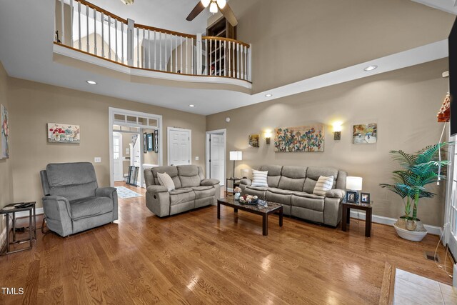 2424 Village Of Wakefield Dr, Zebulon, NC 27597 - living area featuring a towering ceiling, a ceiling fan, wood finished floors, and recessed lighting