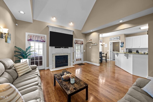 2424 Village Of Wakefield Dr, Zebulon, NC 27597 - living area with light wood-style floors, plenty of natural light, vaulted ceiling, a tile fireplace, and recessed lighting