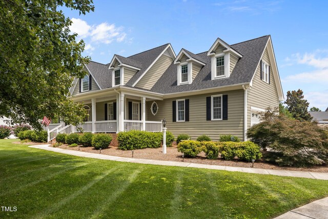 2424 Village Of Wakefield Dr, Zebulon, NC 27597 - new england style home with covered porch, an attached garage, a front lawn, and a shingled roof