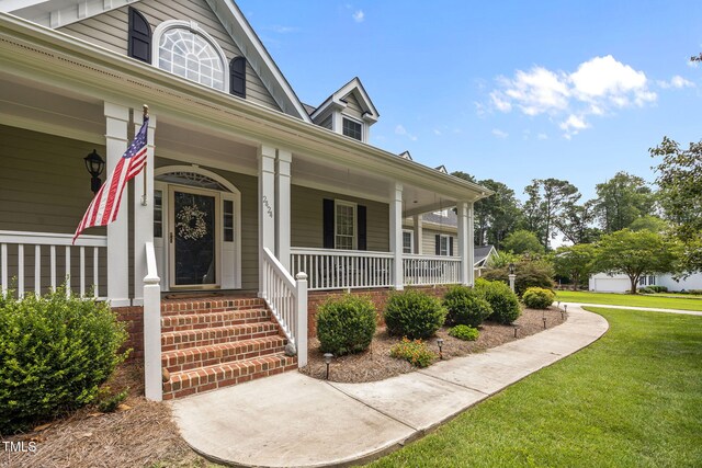 2424 Village Of Wakefield Dr, Zebulon, NC 27597 - property entrance featuring covered porch and a lawn