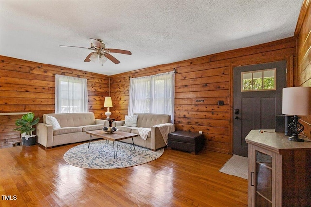 7323 Powell Hooks Rd, Lucama, NC 27851 - living area with healthy amount of natural light, a ceiling fan, wood finished floors, a textured ceiling, and wood walls