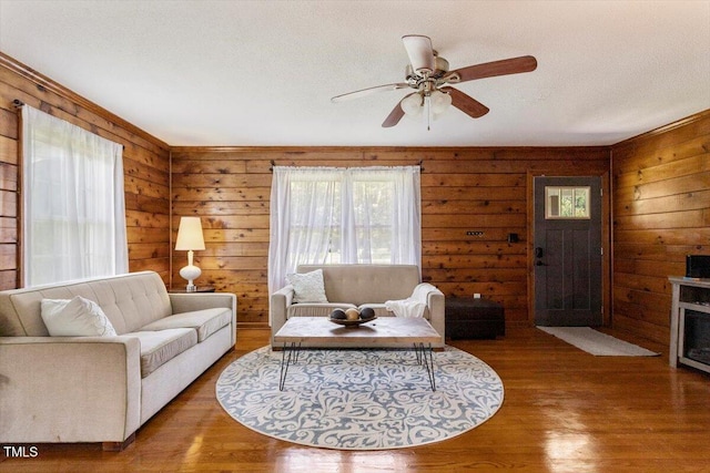 7323 Powell Hooks Rd, Lucama, NC 27851 - living room featuring plenty of natural light, wooden walls, a ceiling fan, and wood finished floors
