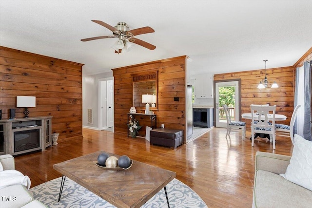 7323 Powell Hooks Rd, Lucama, NC 27851 - living area with a fireplace, wood walls, wood finished floors, and a ceiling fan