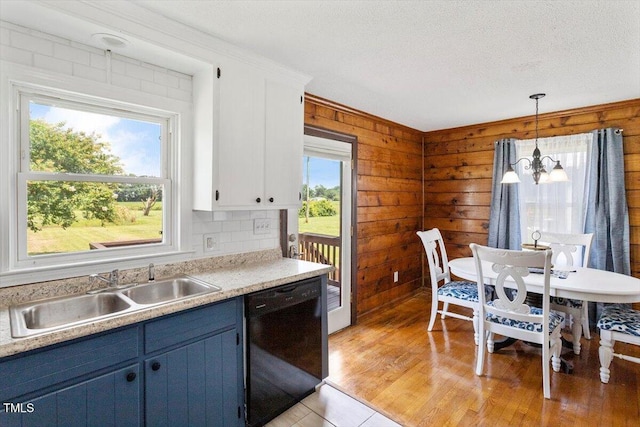 7323 Powell Hooks Rd, Lucama, NC 27851 - kitchen with dishwasher, blue cabinets, light countertops, a chandelier, and wood walls