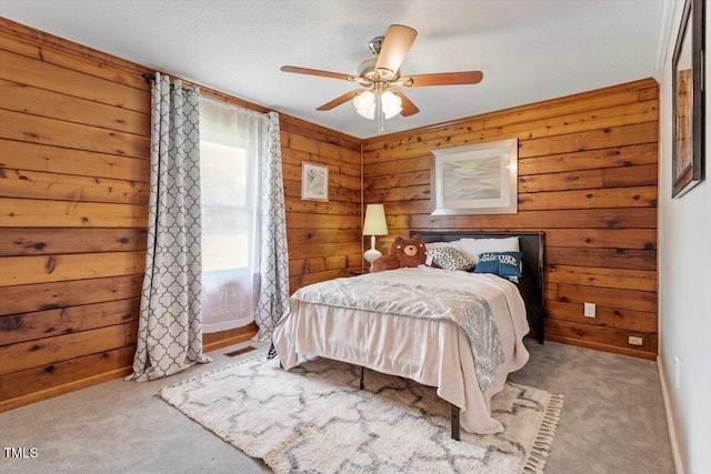 7323 Powell Hooks Rd, Lucama, NC 27851 - carpeted bedroom featuring wood walls, a textured ceiling, and ceiling fan