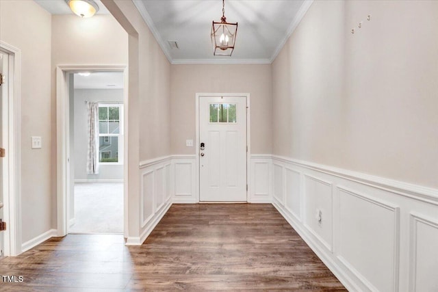 56 E Copenhaver Dr, Clayton, NC 27527 - entrance foyer with healthy amount of natural light, a chandelier, dark wood-type flooring, wainscoting, and crown molding