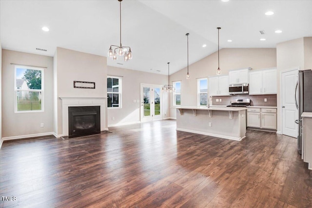 56 E Copenhaver Dr, Clayton, NC 27527 - kitchen featuring appliances with stainless steel finishes, open floor plan, a chandelier, dark wood finished floors, and light countertops