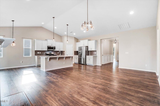 56 E Copenhaver Dr, Clayton, NC 27527 - kitchen with stainless steel appliances, a breakfast bar area, open floor plan, decorative backsplash, and light countertops