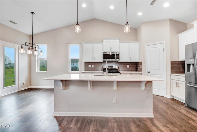 56 E Copenhaver Dr, Clayton, NC 27527 - kitchen with appliances with stainless steel finishes, light countertops, white cabinetry, a kitchen island with sink, and lofted ceiling