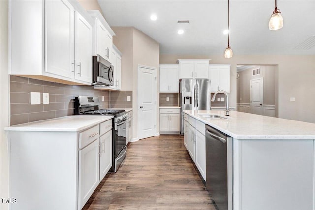 56 E Copenhaver Dr, Clayton, NC 27527 - kitchen with appliances with stainless steel finishes, wood finished floors, white cabinetry, a kitchen island with sink, and recessed lighting