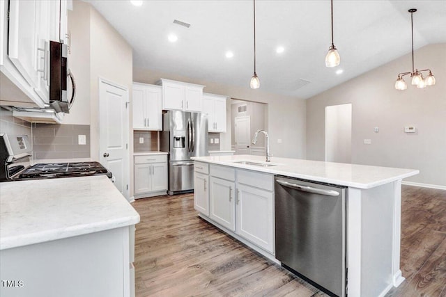 56 E Copenhaver Dr, Clayton, NC 27527 - kitchen featuring appliances with stainless steel finishes, lofted ceiling, light wood finished floors, backsplash, and white cabinets