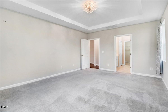 56 E Copenhaver Dr, Clayton, NC 27527 - unfurnished bedroom featuring carpet flooring, a tray ceiling, and a chandelier