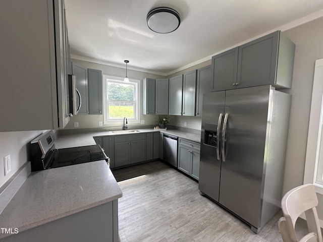 1849 N Main St, Roxboro, NC 27573 - kitchen featuring appliances with stainless steel finishes, light wood finished floors, hanging light fixtures, ornamental molding, and light stone countertops