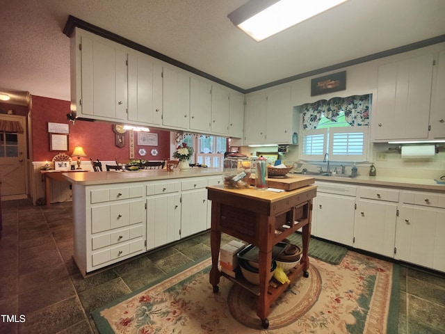 6517 Whitted Rd, Fuquay Varina, NC 27526 - kitchen with light countertops, a peninsula, white cabinetry, and a textured ceiling
