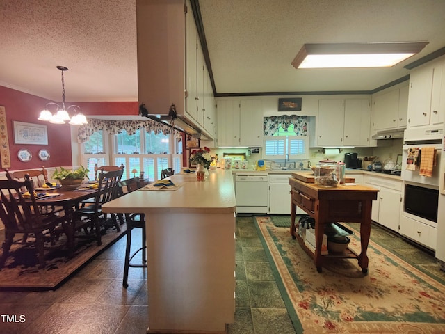 6517 Whitted Rd, Fuquay Varina, NC 27526 - kitchen with white appliances, a textured ceiling, a peninsula, crown molding, and light countertops