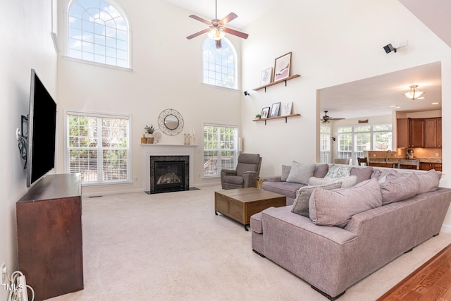 2201 Wide River Dr, Raleigh, NC 27614 - living room featuring a ceiling fan, a high ceiling, a fireplace, and light carpet