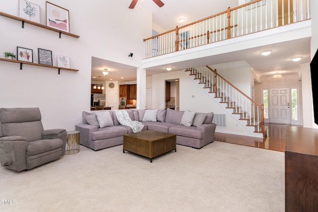 2201 Wide River Dr, Raleigh, NC 27614 - carpeted living room with a ceiling fan, stairway, and a towering ceiling